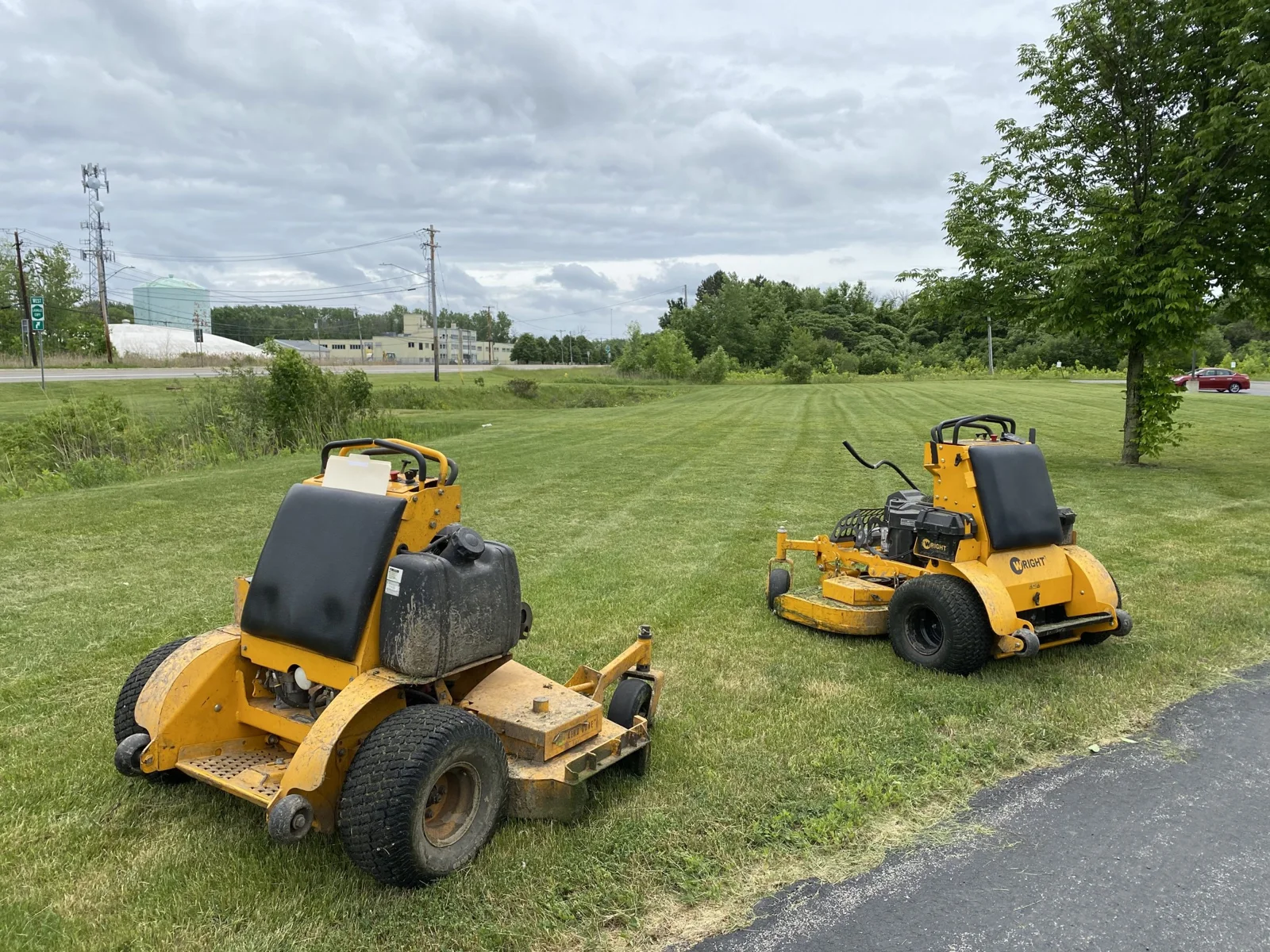 Commercial mowing equipment beside a mown property